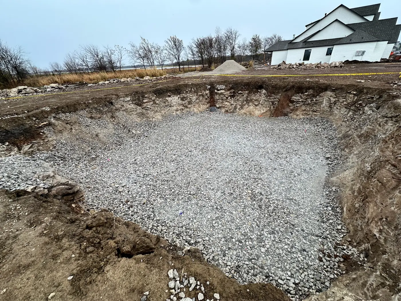 Prepared gravel base inside a deep utility or foundation excavation