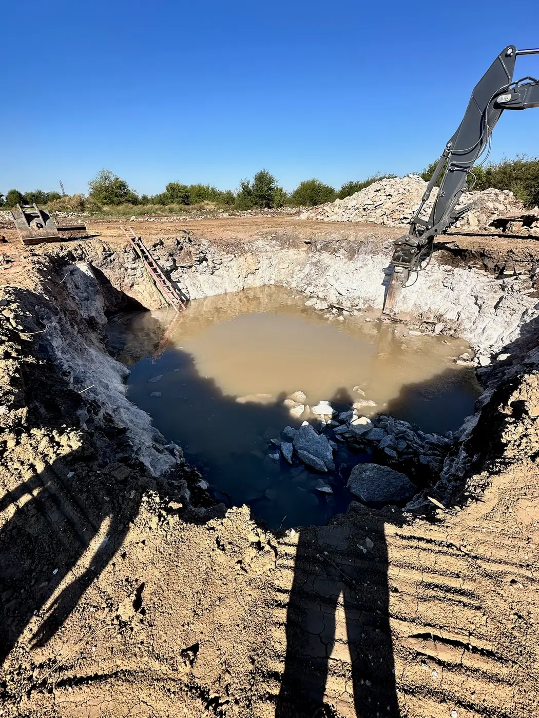 Excavator working through rock in a deep excavation
