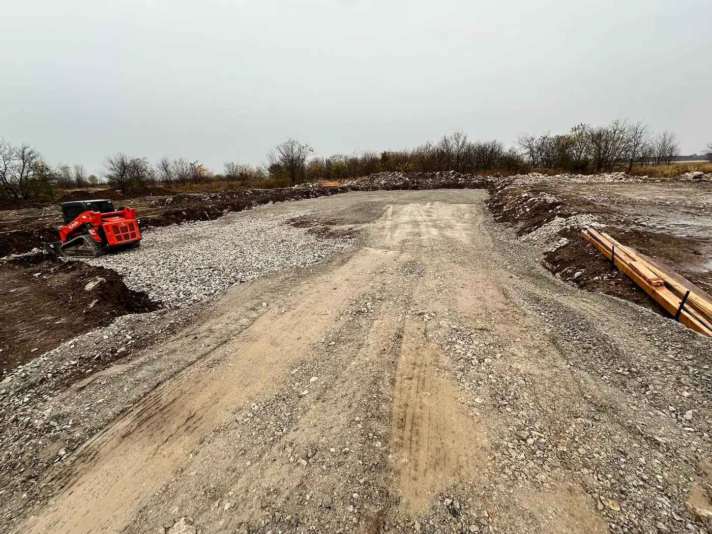 Skid steer working on a gravel building pad