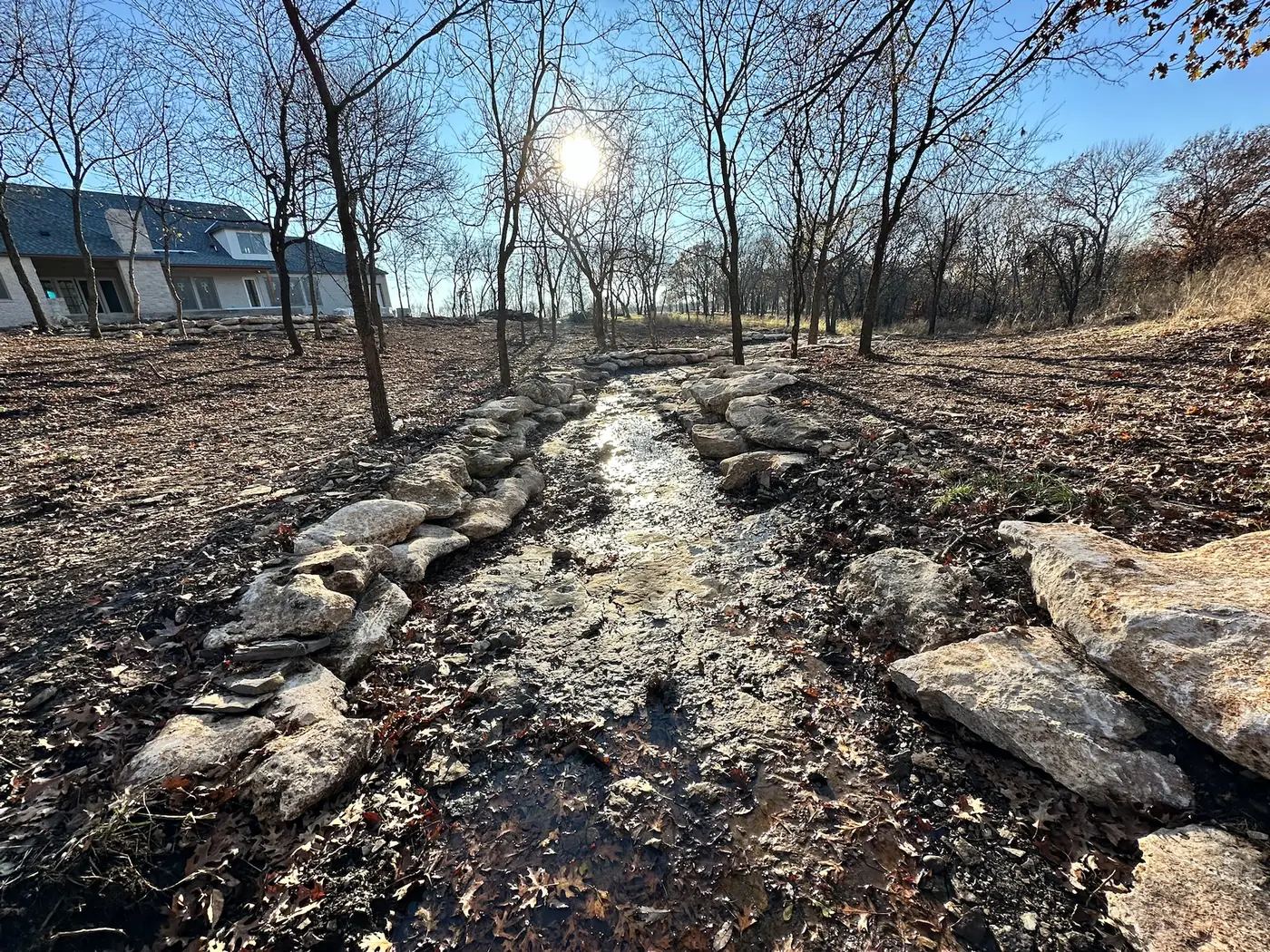 Constructed drainage channel carrying water below a home