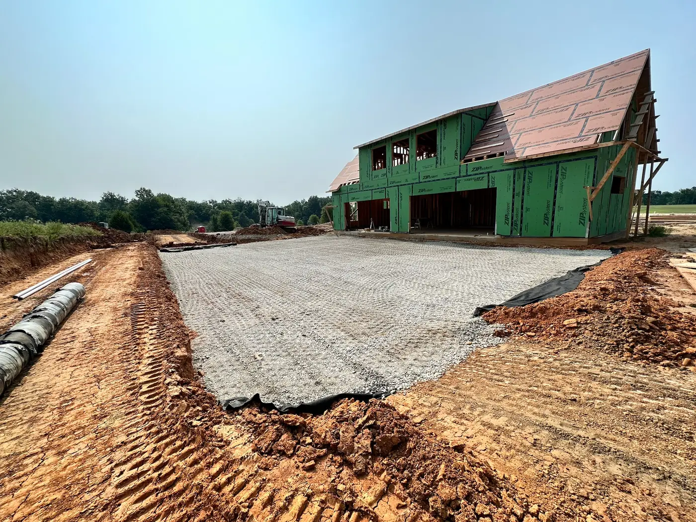 Completed gravel construction base beside a residential build